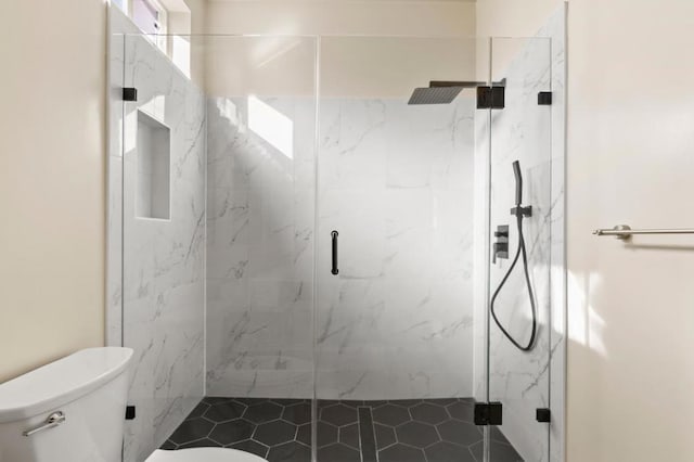 bathroom with an enclosed shower and toilet