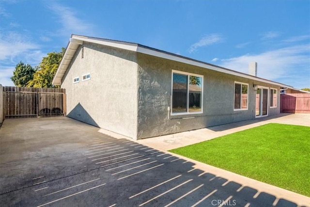 view of side of home featuring a yard and a patio area