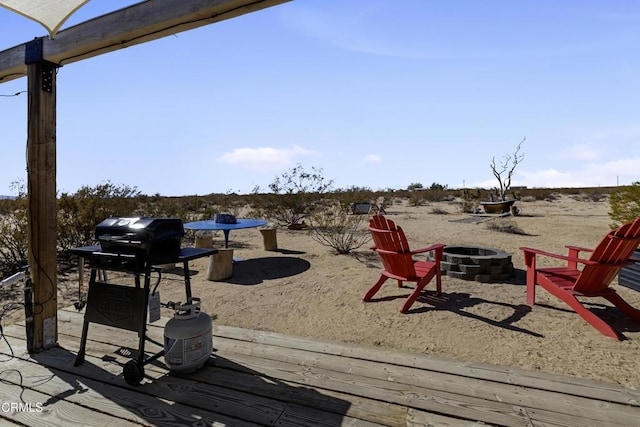 exterior space with an outdoor fire pit and a grill