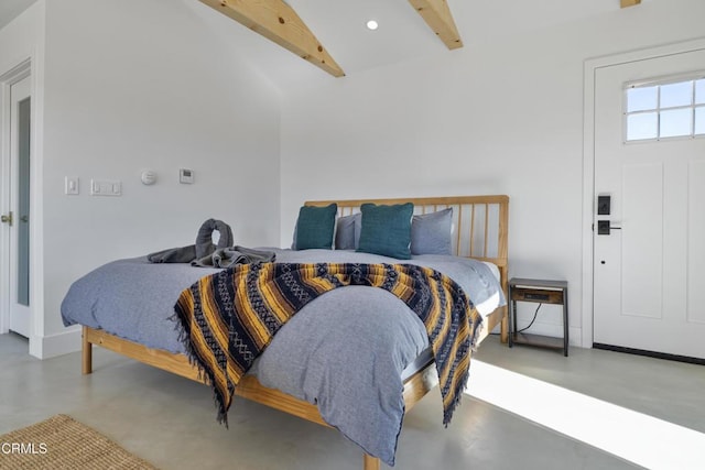 bedroom with lofted ceiling with beams and concrete floors