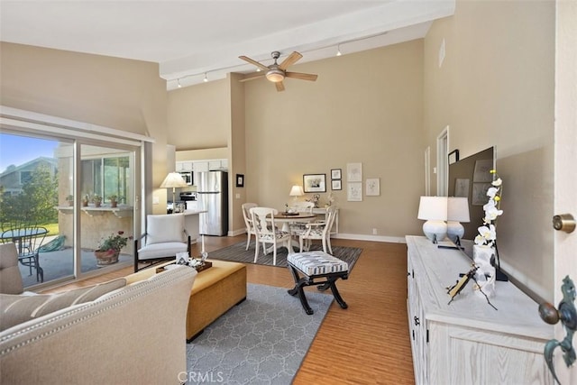 living room with hardwood / wood-style flooring, high vaulted ceiling, rail lighting, and ceiling fan