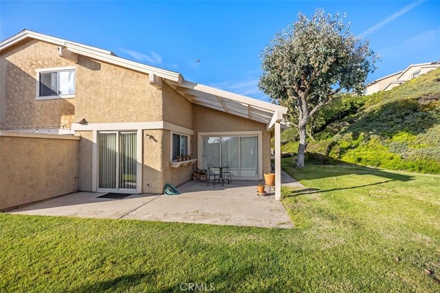 back of house featuring a yard and a patio