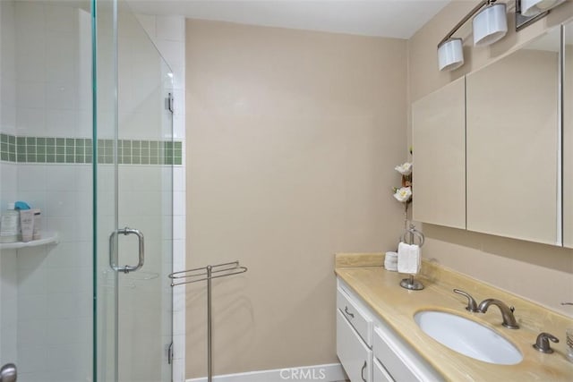 bathroom featuring vanity and a shower with door