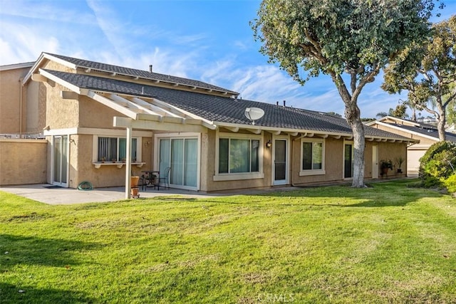 rear view of house with a lawn and a patio area