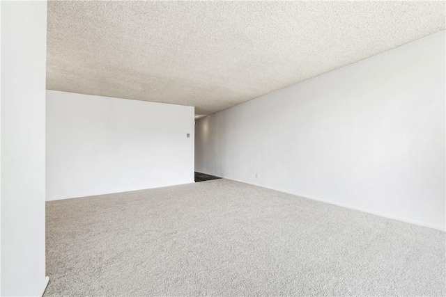 carpeted empty room featuring a textured ceiling