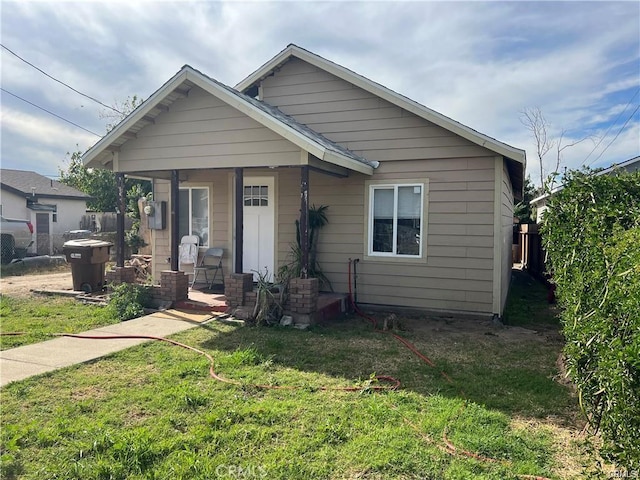 bungalow with a porch and a front lawn