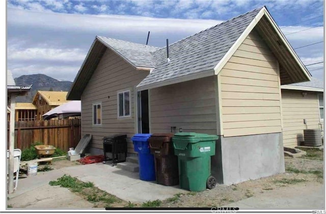 rear view of property with a mountain view, a patio area, and central air condition unit