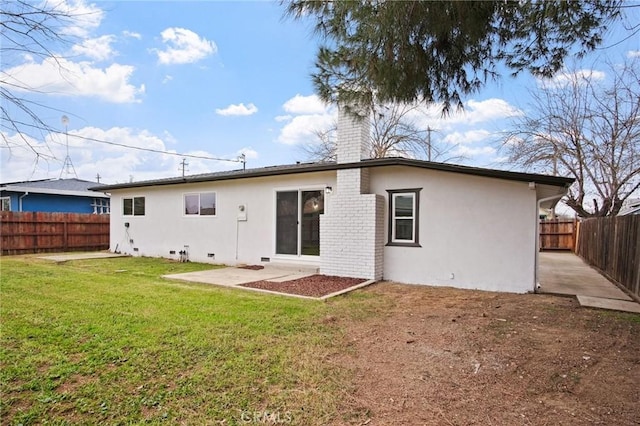 back of house with a lawn and a patio