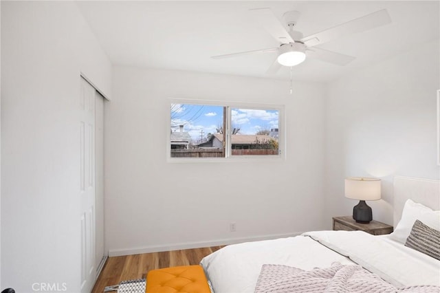 bedroom with wood-type flooring, a closet, and ceiling fan