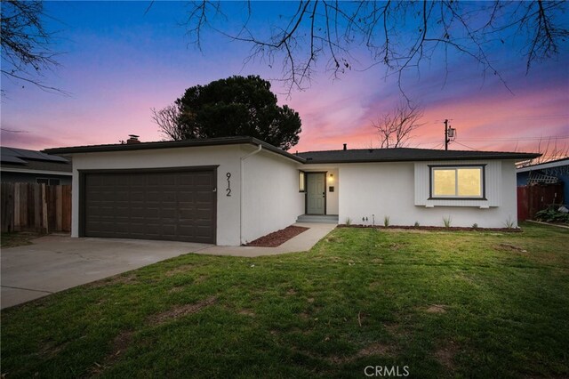 single story home with a garage and a yard