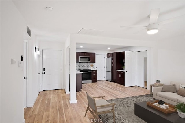 unfurnished living room featuring ceiling fan and light wood-type flooring