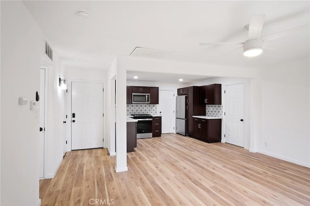 kitchen with ceiling fan, backsplash, dark brown cabinets, stainless steel appliances, and light hardwood / wood-style floors