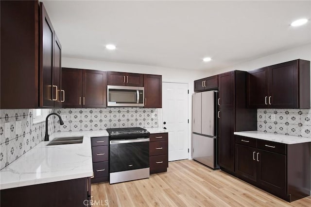 kitchen featuring sink, dark brown cabinets, light hardwood / wood-style flooring, and appliances with stainless steel finishes