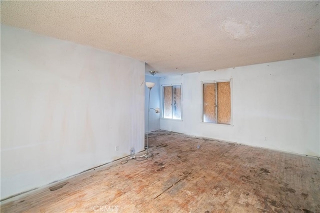 unfurnished room with a textured ceiling