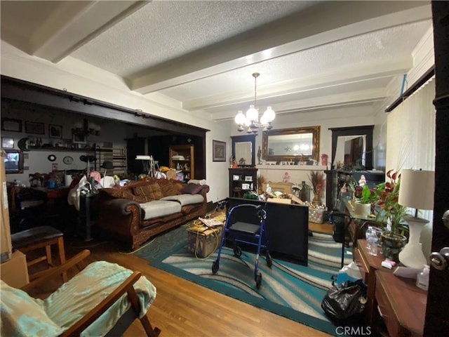 living room with hardwood / wood-style flooring, a textured ceiling, a notable chandelier, and beam ceiling