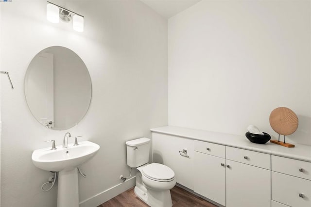 bathroom with sink, hardwood / wood-style floors, and toilet