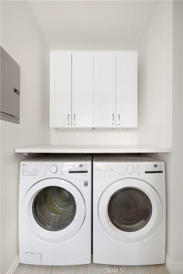 washroom featuring cabinets and separate washer and dryer