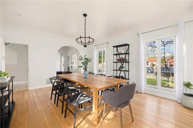 dining area with a notable chandelier and light hardwood / wood-style flooring