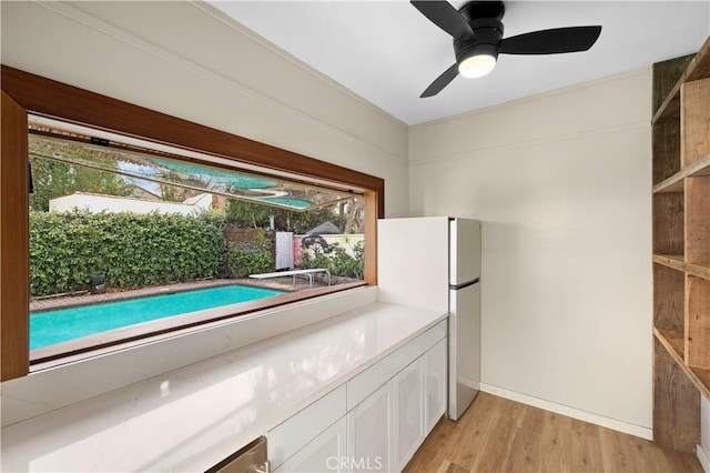 kitchen featuring white refrigerator, white cabinetry, ceiling fan, and light hardwood / wood-style floors