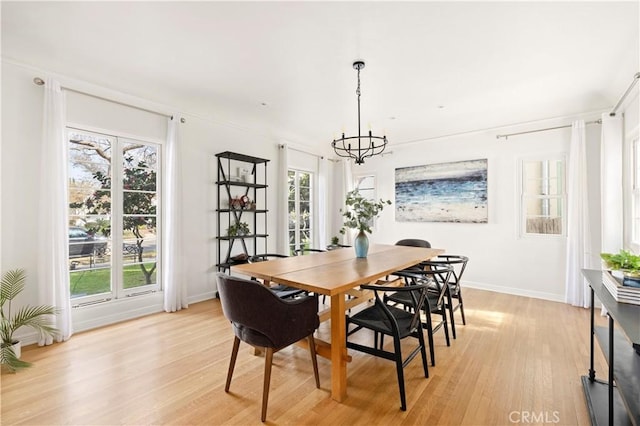 dining space featuring a notable chandelier and light wood-type flooring