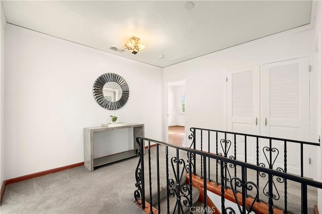 corridor featuring ornamental molding and light colored carpet