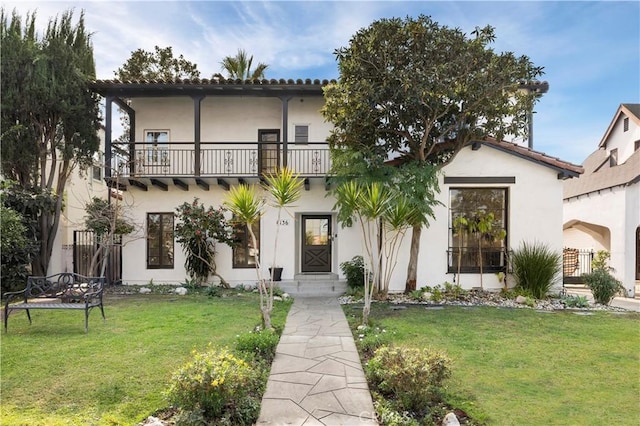 mediterranean / spanish home with a balcony and a front yard