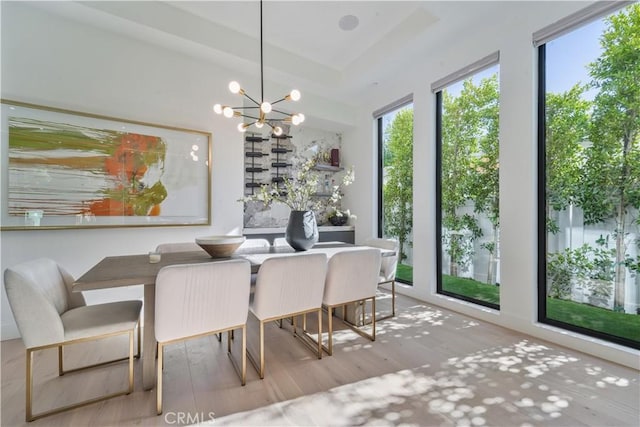 dining room with a wealth of natural light, a chandelier, and light hardwood / wood-style flooring