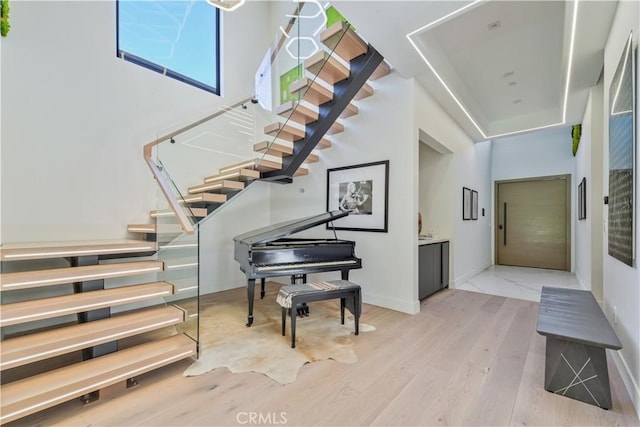 stairs featuring hardwood / wood-style floors and a high ceiling