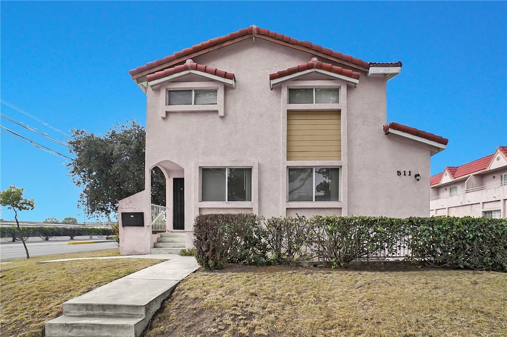 mediterranean / spanish house featuring a front lawn