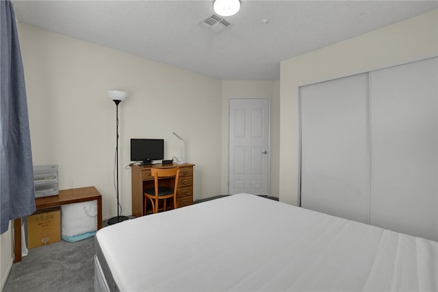 carpeted bedroom featuring a closet and a textured ceiling