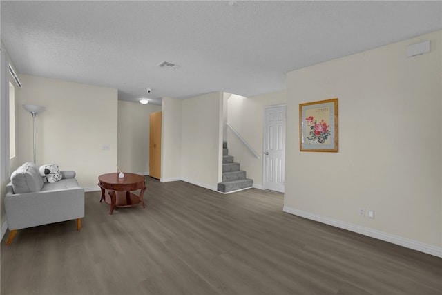 living area featuring dark hardwood / wood-style floors and a textured ceiling