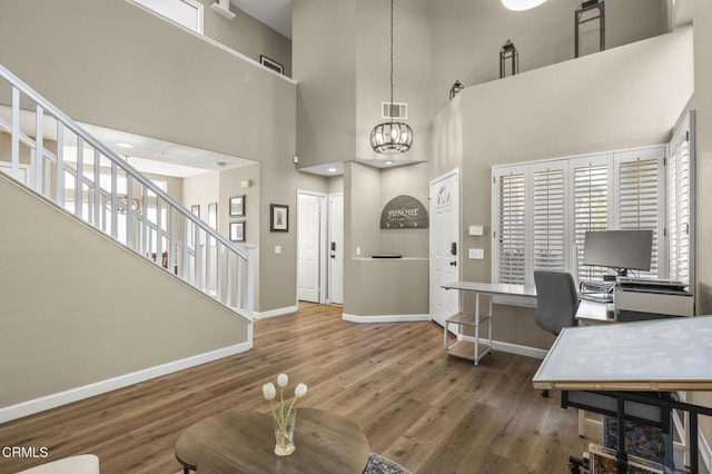 office area with dark hardwood / wood-style floors and a chandelier