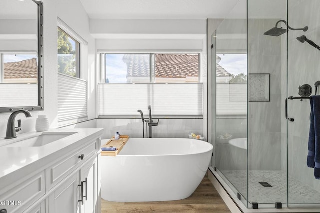 bathroom featuring vanity, hardwood / wood-style floors, and separate shower and tub