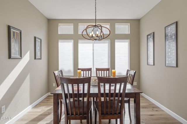 dining area with an inviting chandelier and light hardwood / wood-style flooring