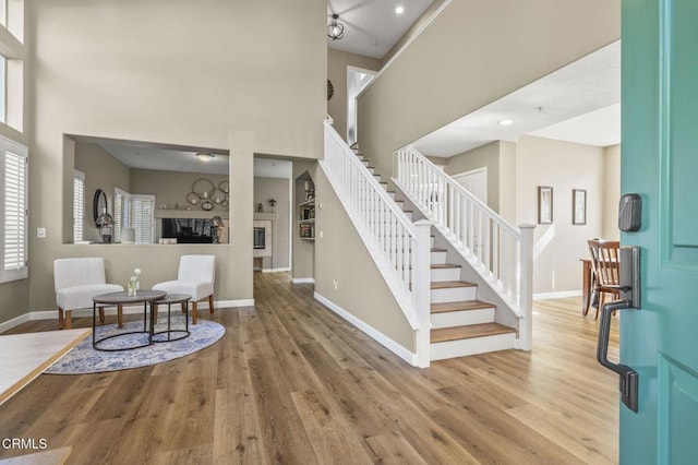 foyer entrance with light wood-type flooring and a high ceiling