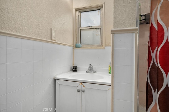 bathroom featuring vanity and tile walls