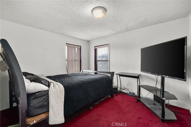 bedroom with dark colored carpet and a textured ceiling