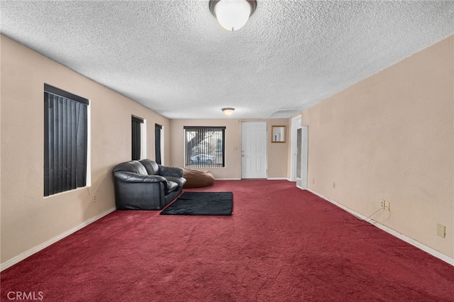 unfurnished room with a textured ceiling and carpet flooring