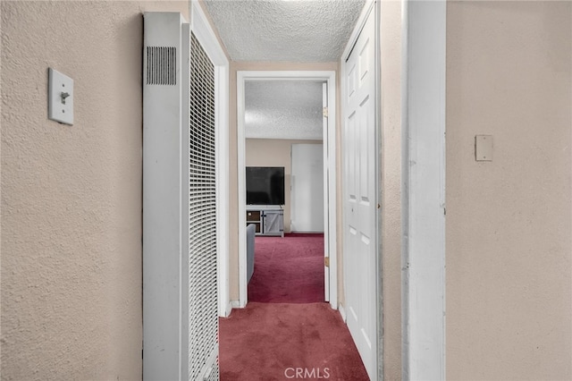 corridor featuring carpet floors and a textured ceiling