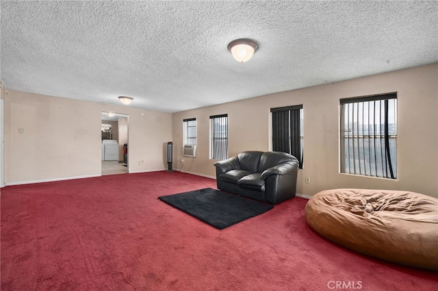 carpeted living room featuring cooling unit, washer / clothes dryer, and a textured ceiling