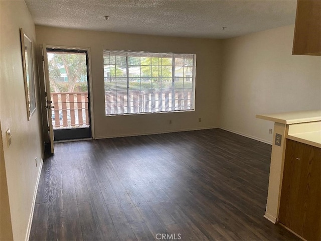 unfurnished dining area featuring dark hardwood / wood-style floors and a textured ceiling