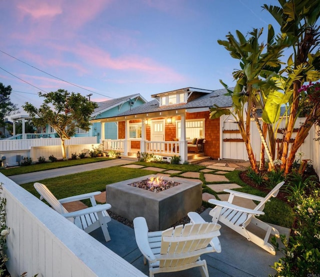 exterior space with a porch and an outdoor fire pit