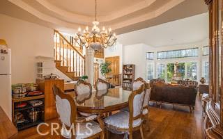 dining room with a raised ceiling, hardwood / wood-style floors, and a notable chandelier