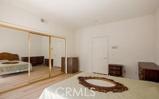 bedroom featuring hardwood / wood-style floors and a closet