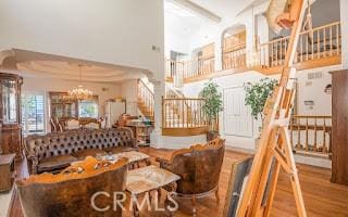 dining area featuring hardwood / wood-style floors, a towering ceiling, and a chandelier