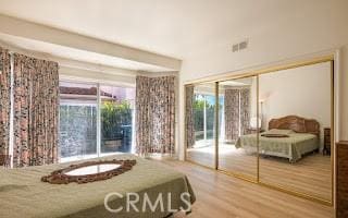 bedroom featuring access to exterior and wood-type flooring