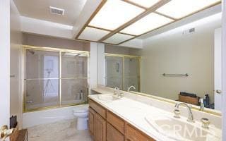 full bathroom featuring enclosed tub / shower combo, vanity, and toilet