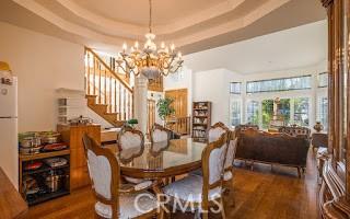 dining space featuring dark hardwood / wood-style floors, a tray ceiling, and a chandelier