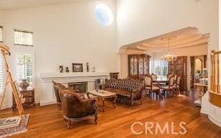 interior space featuring an inviting chandelier, hardwood / wood-style flooring, a raised ceiling, and a towering ceiling