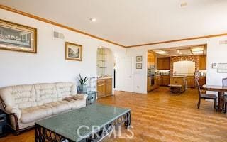 living room with hardwood / wood-style flooring and ornamental molding